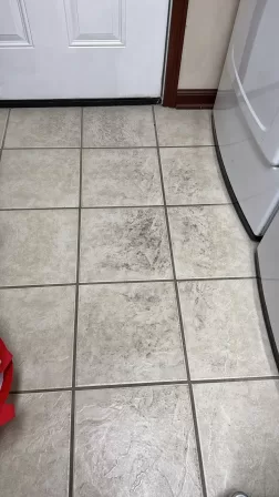 Dirty laundry room floor with stains and buildup before deep cleaning service