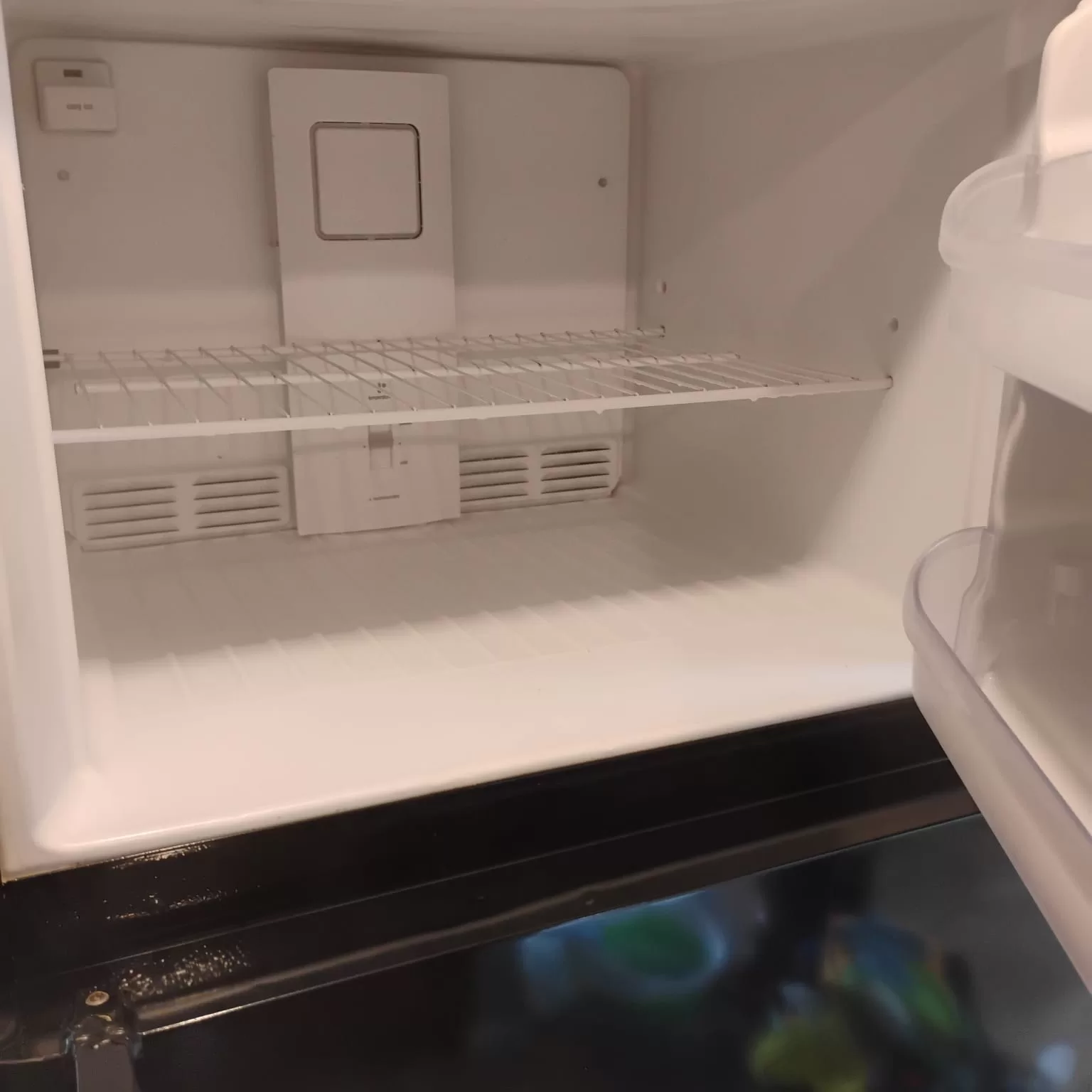 Clean refrigerator interior after professional move-out cleaning showing sanitized shelves