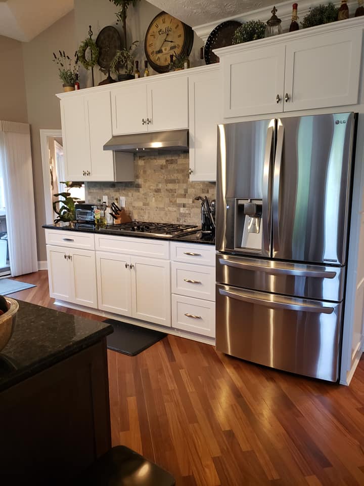 Professional kitchen cleaning results showing spotless white cabinets and stainless steel appliances in Dayton OH